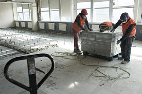 Les travailleurs empilent les panneaux de plancher sur une palette